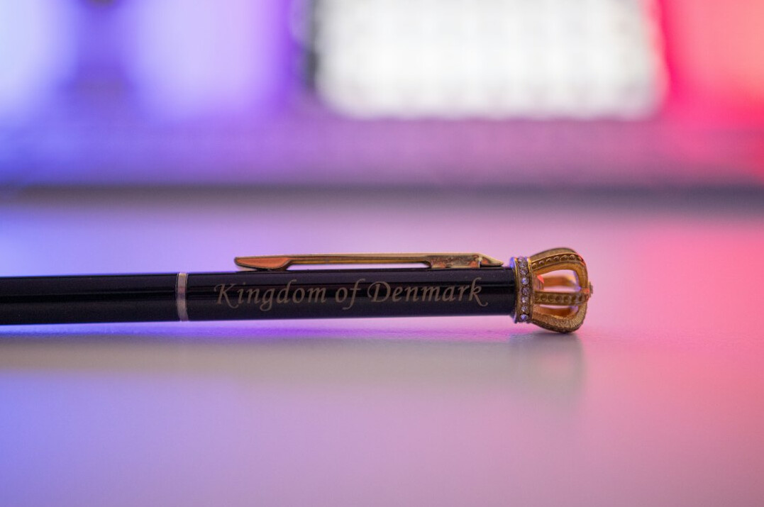 Handwritten notes in a notebook with a pen on a wooden desk