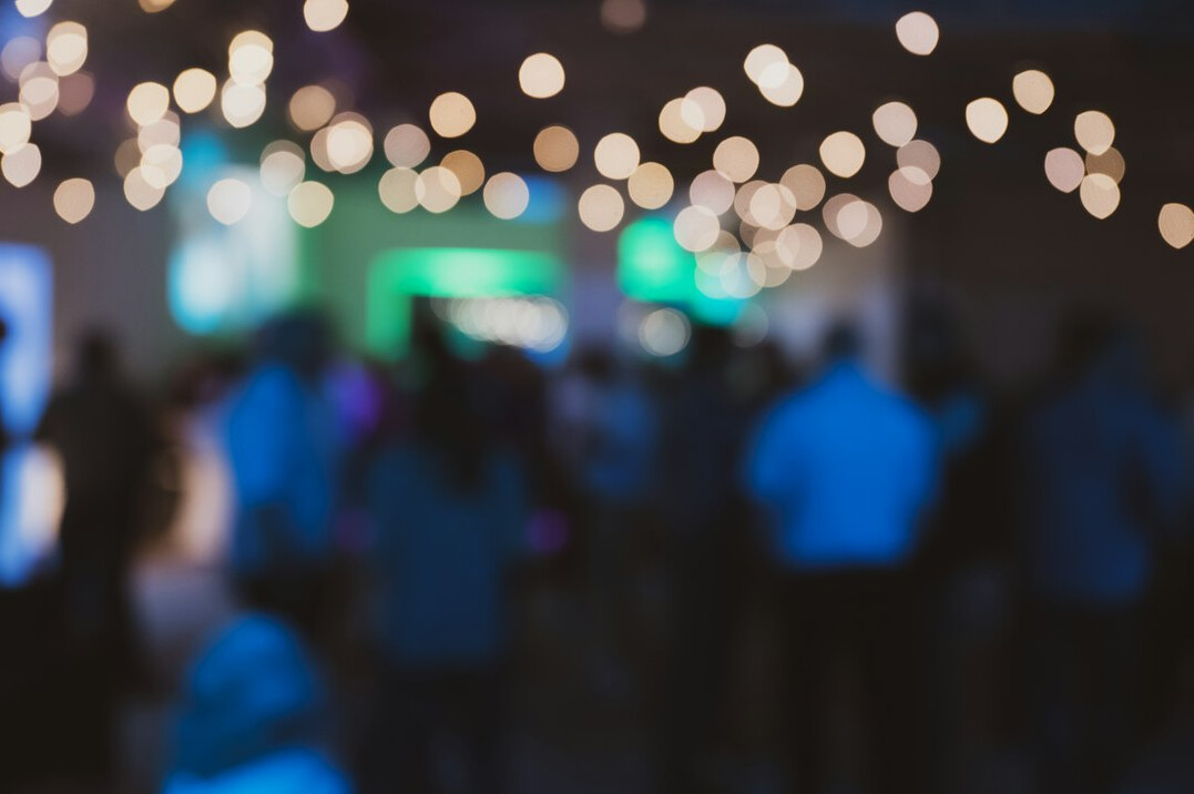 Blurred distant crowd at an evening event with soft stage lights